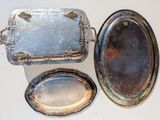 three silver trays sitting on top of a table next to each other