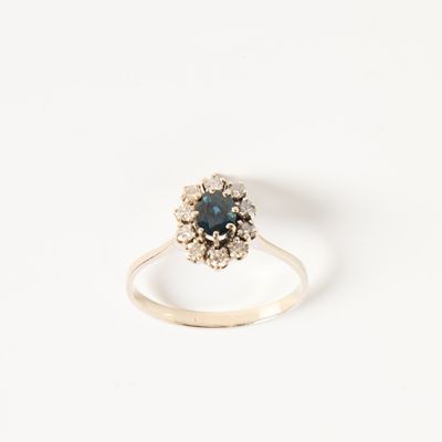 une image représentant une bague ornée d'une pierre bleue entourée de diamants blancs