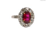 une image d'une bague ornée d'un rubis entouré de diamants blancs