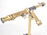 an antique brass telescope on a tripod stand against a white background