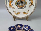 deux assiettes ornées de motifs bleus et dorés, posées sur une surface blanche