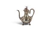 une théière ancienne en argent posée sur un support, sur fond blanc