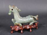 a figurine of a horse that is sitting on a tree branch