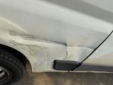 a close up of a white car with a flat tire
