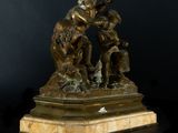 a bronze statue of a boy and girl sitting on a rock