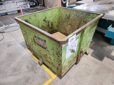 un grand conteneur vert posé au milieu d'un entrepôt