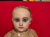 a small doll that is sitting on a red chair