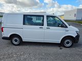 the white van is parked in a parking lot near a building