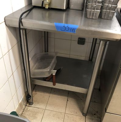 une petite cuisine avec un plan de travail en inox et un micro-ondes