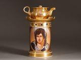 a gold tea pot with a picture of a man on it