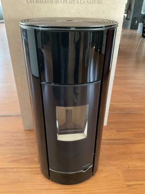 une photo d'une cafetière noire posée sur un parquet