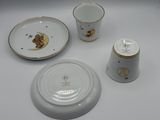 a white plate with a gold trim and a cup and saucer