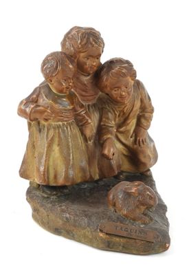 une statue représentant deux enfants et un chien sur un rocher