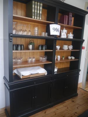 a black china cabinet with a lot of dishes and glasses on it