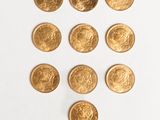 several gold coins are arranged in a triangle on a white surface