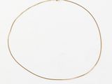 a gold chain necklace with a gold clasp on a white surface