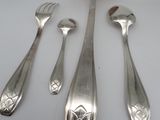 four silver spoons and a fork on a white surface