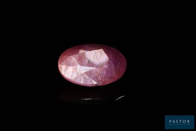 a close up of a pink stone on a black surface
