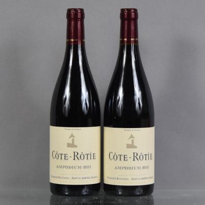 two bottles of wine sitting on top of a table next to each other