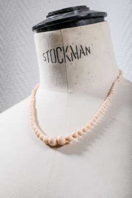 a close up of a mannequin torso with a necklace on it
