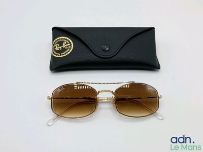 une paire de lunettes de soleil et son étui posés sur une surface blanche, avec un étui noir