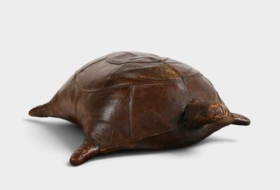tortue en cuir marron sur fond blanc