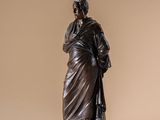statue of a man with a cane standing on a marble base
