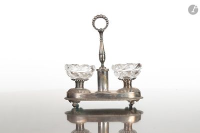 un bougeoir en argent sur lequel sont posées trois bougies en cristal