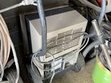 un petit chariot sur lequel est posé un ordinateur, à côté d'une pile d'autres objets