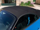 a blue car with a black top parked in front of a building