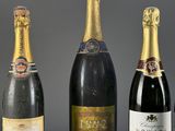 three bottles of champagne are lined up on a table
