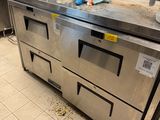 stainless steel counter top in a commercial kitchen with a lot of clutter on the floor