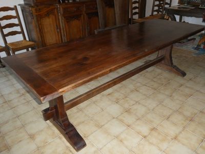 une table en bois qui se trouve dans une pièce avec des chaises