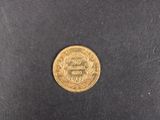 a close up of a gold coin on a black surface