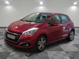 une voiture rouge est garée dans une pièce au sol en damier