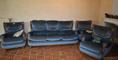 un canapé bleu et deux chaises dans un salon