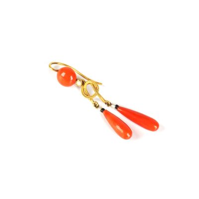 une photo d'une paire de boucles d'oreilles rouges rehaussées de touches dorées