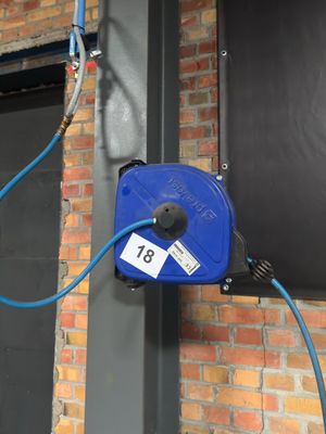 a blue hose attached to the side of a brick building