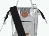 a small silver bag with a black strap and a tag on it