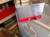 une machine posée par terre à côté d'un évier