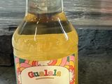 a bottle of lemon syrup sitting on the ground