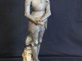 statue of a man in armor with a dog on a black background
