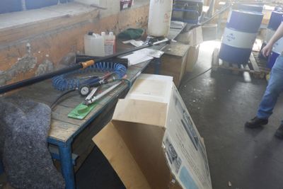 un homme debout à côté d'une table sur laquelle sont posés divers objets