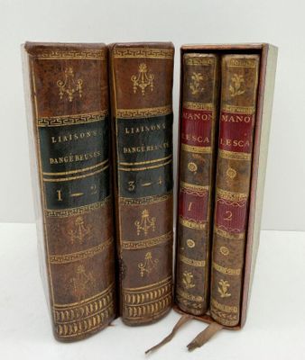 trois vieux livres posés l'un sur l'autre sur une table