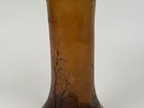a brown vase with a tree on it sitting on a table