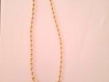 un collier de perles dorées posé sur une feuille de papier