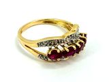 a close up of a gold ring with a ruby stone and diamonds