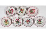six assiettes ornées de motifs floraux, posées sur une surface blanche