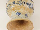 a blue and white vase sitting on a white surface