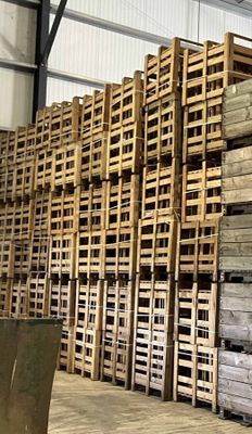 de nombreuses palettes de bois empilées dans un entrepôt